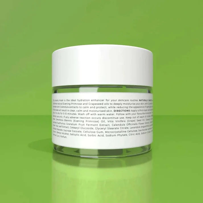 a jar of naturally smooth face mask 50ml on a green surface.